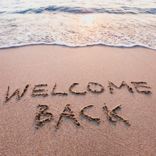 Beach with the words "Welcome Back" written in the sand for vacation recovery